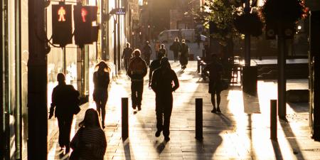 People walking on the street in silhouette in the Sydney CBD.